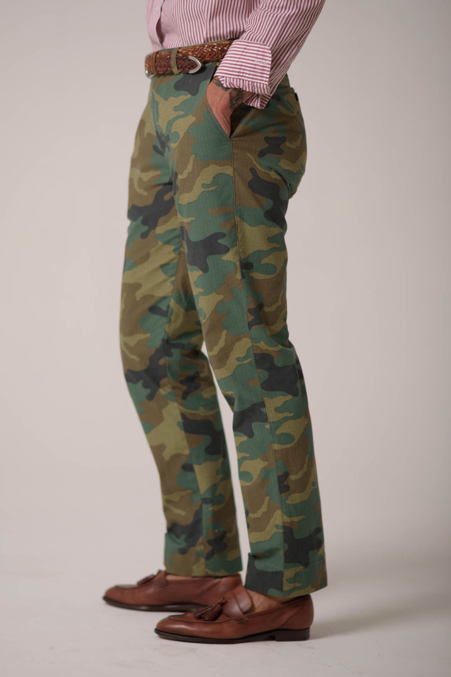 Person wearing camouflage pants with a plain background